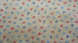 Alphabet fabric colored letters, tan background